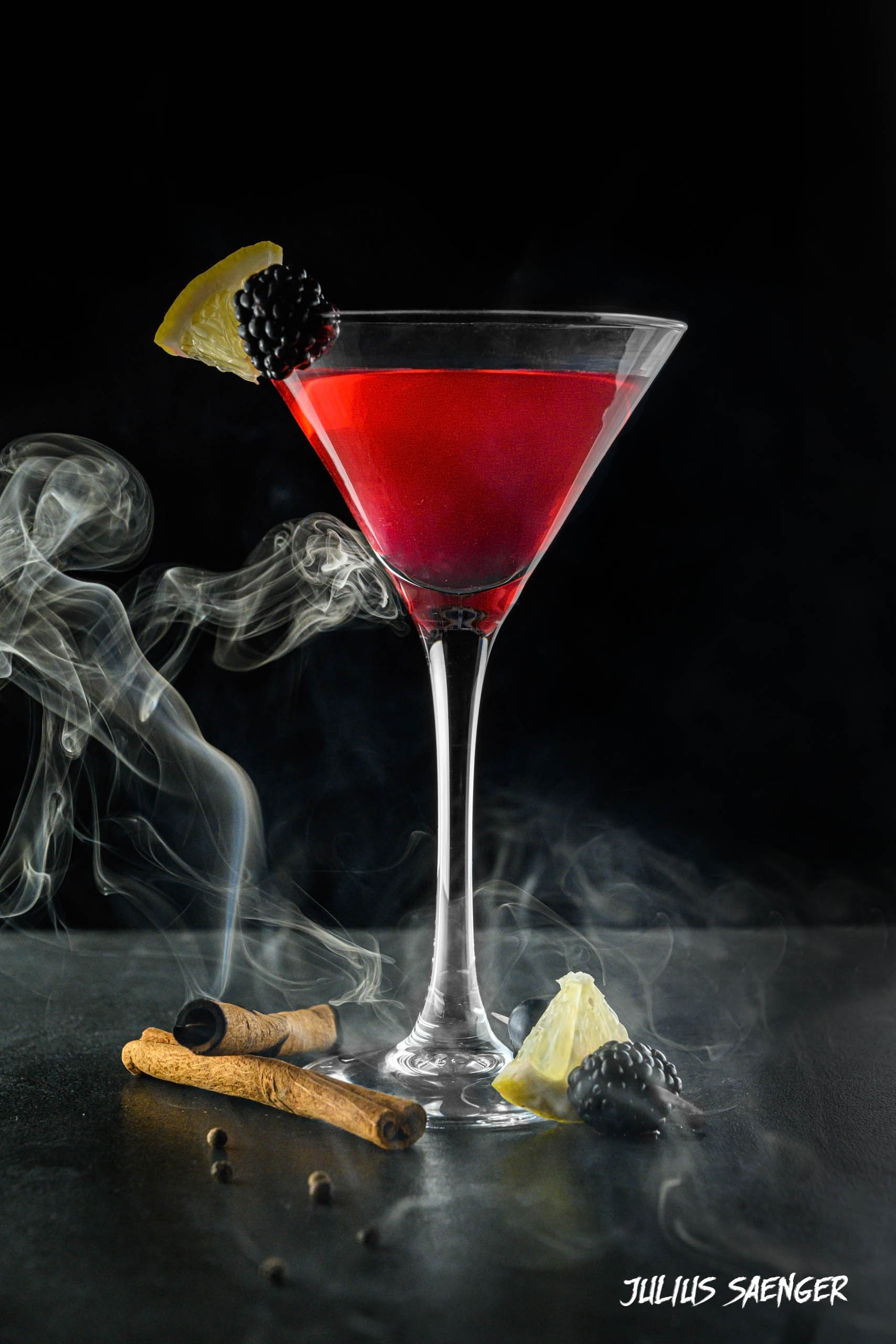 Foto von einem Roten Cocktail und einer angezündeten Zimtstange