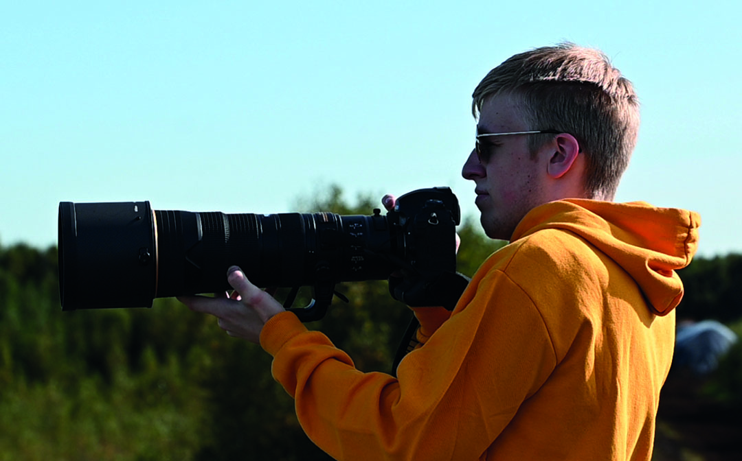 Julius Saenger mit Kamera und Superteleobjektiv